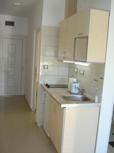 a kitchen with white cabinets and a sink at Apartments Villa Danilovic in Herceg-Novi