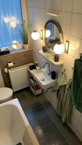 a bathroom with a sink and a tub and a mirror at Großes Juwel-Monteurzimmer-Privatzimmer in Wetzlar