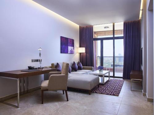ein Wohnzimmer mit Sofa und Tisch in der Unterkunft Mercure Dubai Barsha Heights Hotel Suites And Apartments in Dubai
