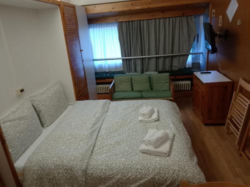 a bedroom with a bed with two white towels on it at Appartamento Artuik Marilleva 1400 in Marilleva