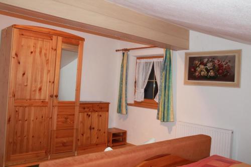 sypialnia z drewnianą szafką i oknem w obiekcie Ferienwohnung Tummener w mieście Zell am Ziller