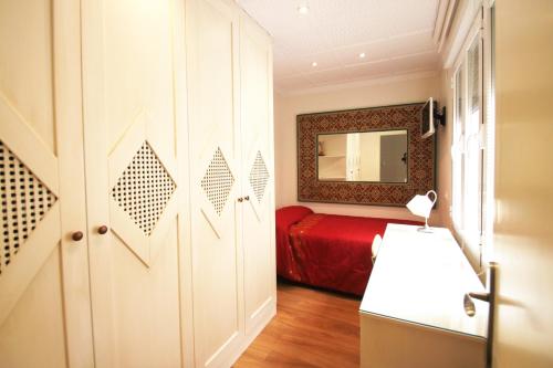 - une chambre avec un lit rouge et un miroir dans l'établissement CasaTuris Pintor Lorenzo A105, à Alicante