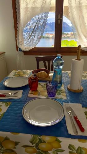 a table with plates and utensils on a blue table cloth at VistaBellaBorromeoFlat in Baveno