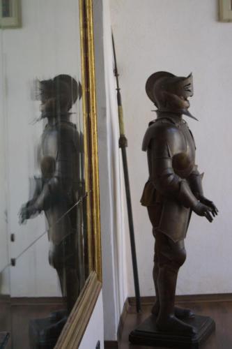 a statue of a man with a spear in front of a mirror at Castello Di Compiano Hotel Relais Museum in Compiano