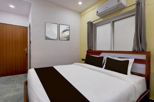 a bedroom with a large white bed and a window at Super Collection O Lorven Grand in Visakhapatnam