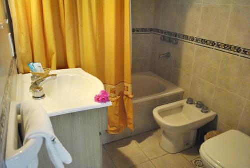 y baño con lavabo, aseo y bañera. en Cabañas Patagonia en Villa Gesell