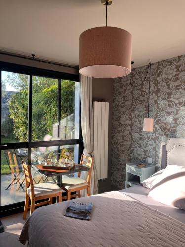 a bedroom with a bed and a table and chairs at Au gré des vents in Saint-Quay-Portrieux