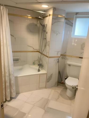 a bathroom with a toilet and a tub and a sink at 2BR Seaview Condo with Balcony, Riviera Bay Resort Melaka in Malacca