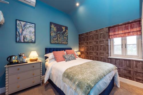 a bedroom with blue walls and a bed and a window at The Station at Shustoke - Birmingham Airport & NEC in Shustoke
