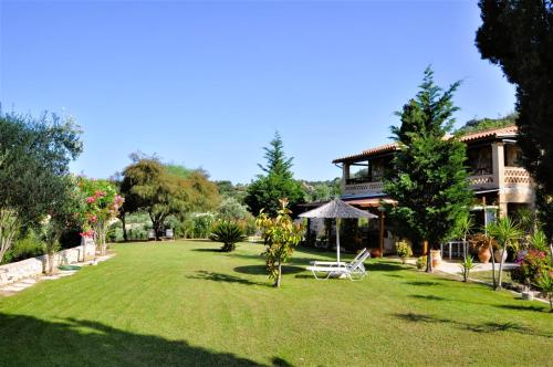 a house with a large yard with a building at Villa Belvedere - Panoramic Sea View apts in Vasilikos