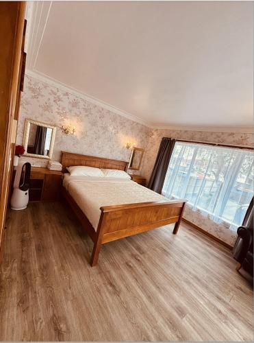 a bedroom with a bed and a large window at Auckland Airport Guest House in Auckland