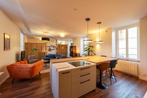 an open kitchen and living room with a table and chairs at Le St Géraud, 3 chambres, Prémium avec Fibre, Centre Aurillac in Aurillac