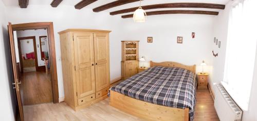 a bedroom with a bed with a checkered blanket at Gîte Le Merle 90m2 près de la route des vins in Ammerschwihr