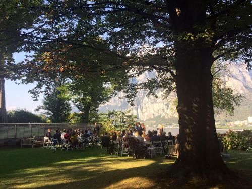 a group of people sitting in chairs under a tree at Casa Sull'Albero in Malgrate