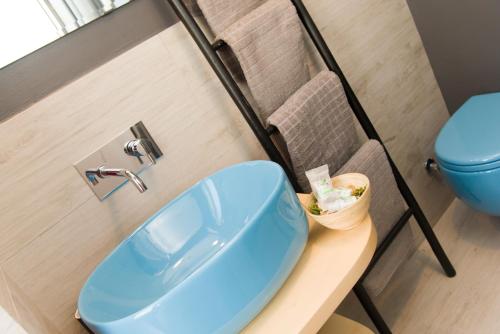 a bathroom with a blue sink and a toilet at Matinee Rooms in Mattinata