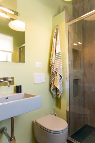 a bathroom with a toilet and a sink and a shower at Matinee Rooms in Mattinata