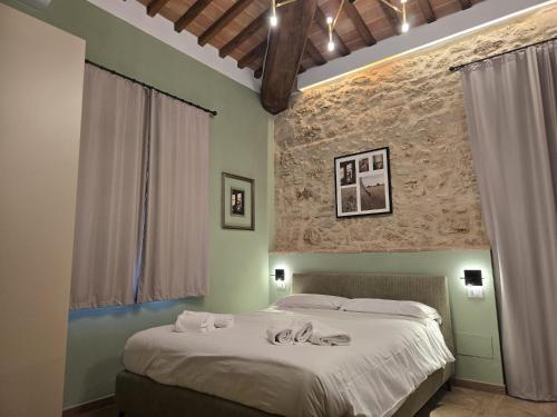 a bedroom with a large bed with towels on it at Il Podere Orto in San Gimignano