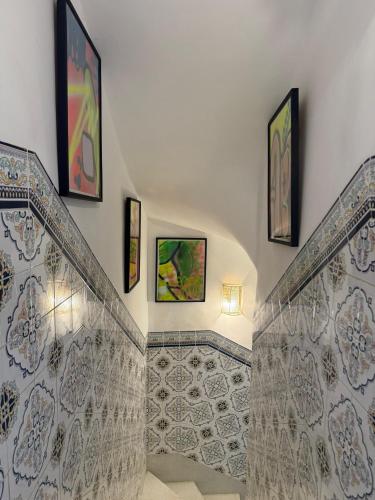 a staircase with art on the walls of a house at Riad R Art in Marrakesh