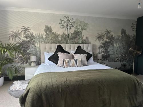 a bedroom with a large bed with plants on the wall at Riverview House in Minnigaff