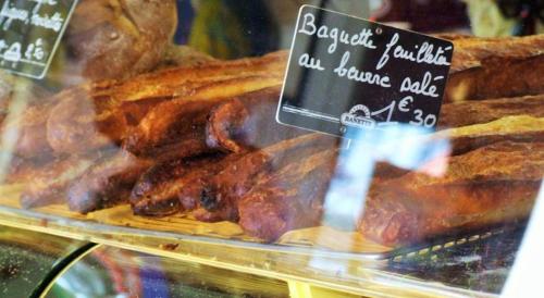a display case in a bakery with meat and bread at Les Hirondelles in Lyons-la-Forêt
