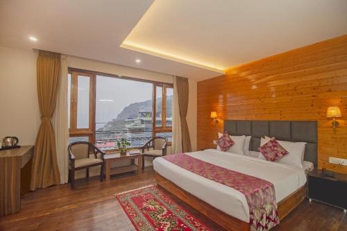 a hotel room with a bed and a balcony at Royal Hotel Gangtok in Gangtok