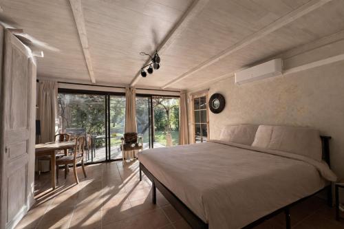 a bedroom with a bed and a table with a desk at Mas la Provence in L'Isle-sur-la-Sorgue