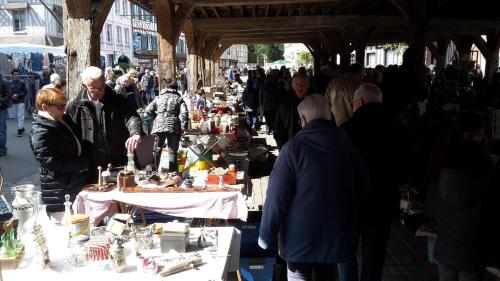 a crowd of people walking around a market with tables filled with items at Les Hirondelles in Lyons-la-Forêt