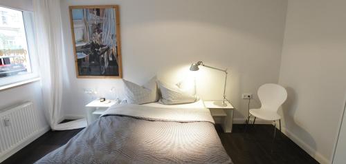 a bedroom with a bed and a desk and a lamp at quartier kiel in Kiel