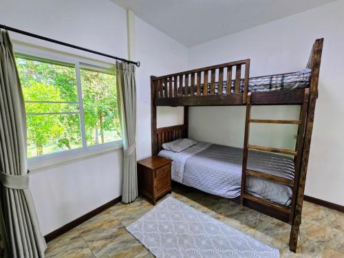 a bedroom with a bunk bed and a window at Anusorn Villas & Garden Oasis - Peaceful Chiang Mai Hideaway in Ban Ton Chok
