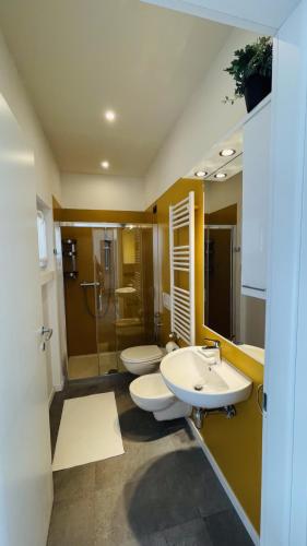 a bathroom with two sinks and a shower and two toilets at Comodissimo Gaslini e mare in Genoa