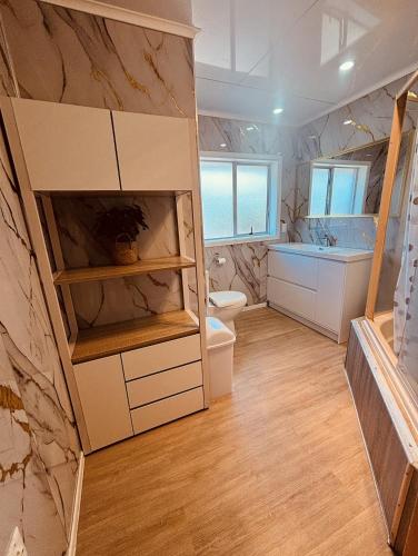 a bathroom with a toilet and a sink and a tub at Auckland Airport Guest House in Auckland