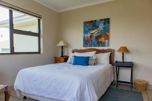 a bedroom with a large white bed and a window at Bona Vista in Pringle Bay