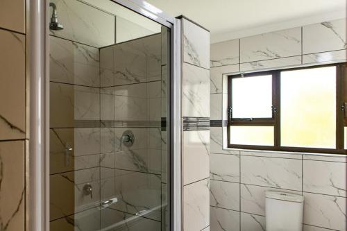 a bathroom with a shower with a glass door at Bona Vista in Pringle Bay