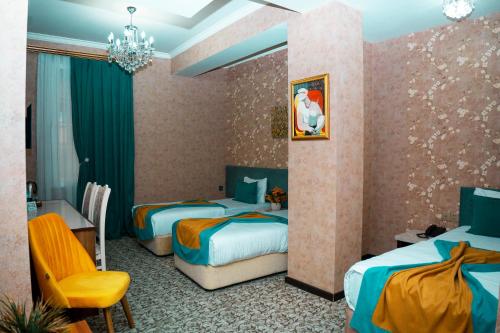 a hotel room with two beds and a chair at Nemi Boutique Hotel in Baku