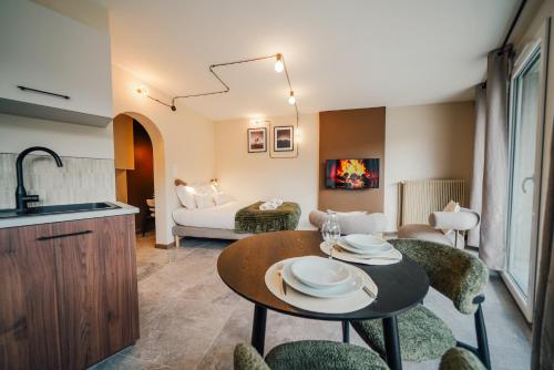 a kitchen and living room with a table and chairs at Studio Arclusaz by ExplorHome in Albertville