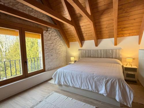 a bedroom with a bed and a large window at Borda del Llano in Bielsa