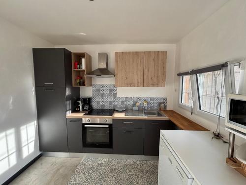 a kitchen with a sink and a stove top oven at "Chambre" Chez Zabou in Carpentras