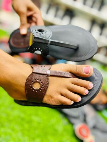 a person holding a pair of sandals with their hands at Mabegi african Designs in Arusha