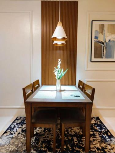 a dining room table with a vase of flowers at JB Casa del Alivio in Butuan