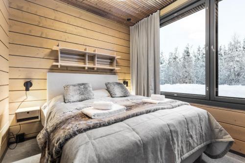 a bedroom with a bed and a large window at Bimmel Arctic Suite by PolarVillas in Kittilä
