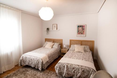 a bedroom with two beds and a window at Tres Coronas in Olite