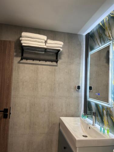 un bagno con lavandino, specchio e asciugamani di Aparan Hotel a Aparan