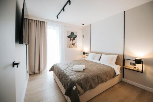 a bedroom with a large bed and a window at DG Apartamenty Bulwary-Apartament Sombrero Verde in Mielec