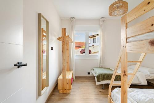a bedroom with two bunk beds and a window at O Lar de Laura Casa familiar para escapada tranquila con piscina y sala de juegos cerca de Vigo in Vigo