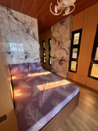 a bed in a room with a marble wall at Gavins Nest in Romblon