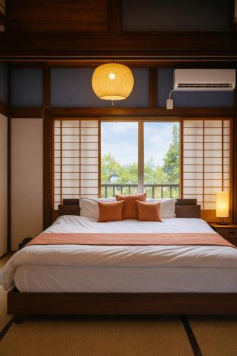 a bedroom with a large bed with two windows at Macchiato SHONAN - 綺麗な古民家一棟貸切-海まで5分-無料駐車場-自転車2台-独立乾燥機-お子様大歓迎 Private Traditional House Near Kamakura Hakone, Family-Friendly Stay in Hiratsuka