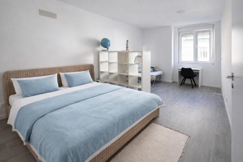a bedroom with a large bed with blue sheets at Casa Silva Diamond in Pinhal Novo