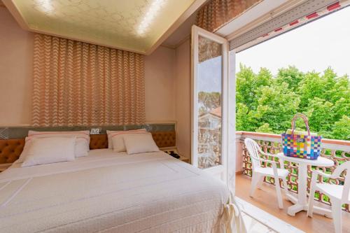 a bedroom with a bed and a large window at Hotel Matilde in Marina di Massa