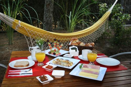 a table with food and drinks on a hammock at Kaia Apart y Spa in Mar de las Pampas