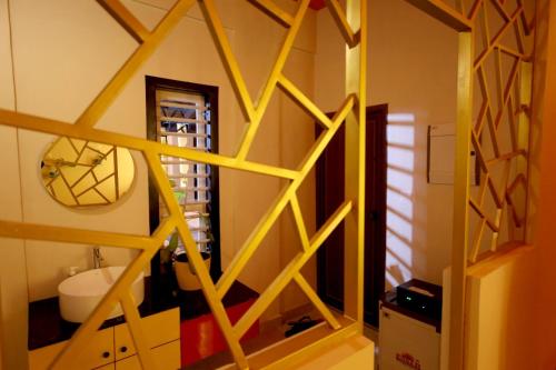 a room with a yellow wooden staircase with a mirror at Skylark Home in Mananthavady